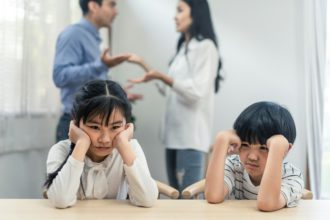 Two young children feeling sad and boring due to parents aggressive trouble fighting at home